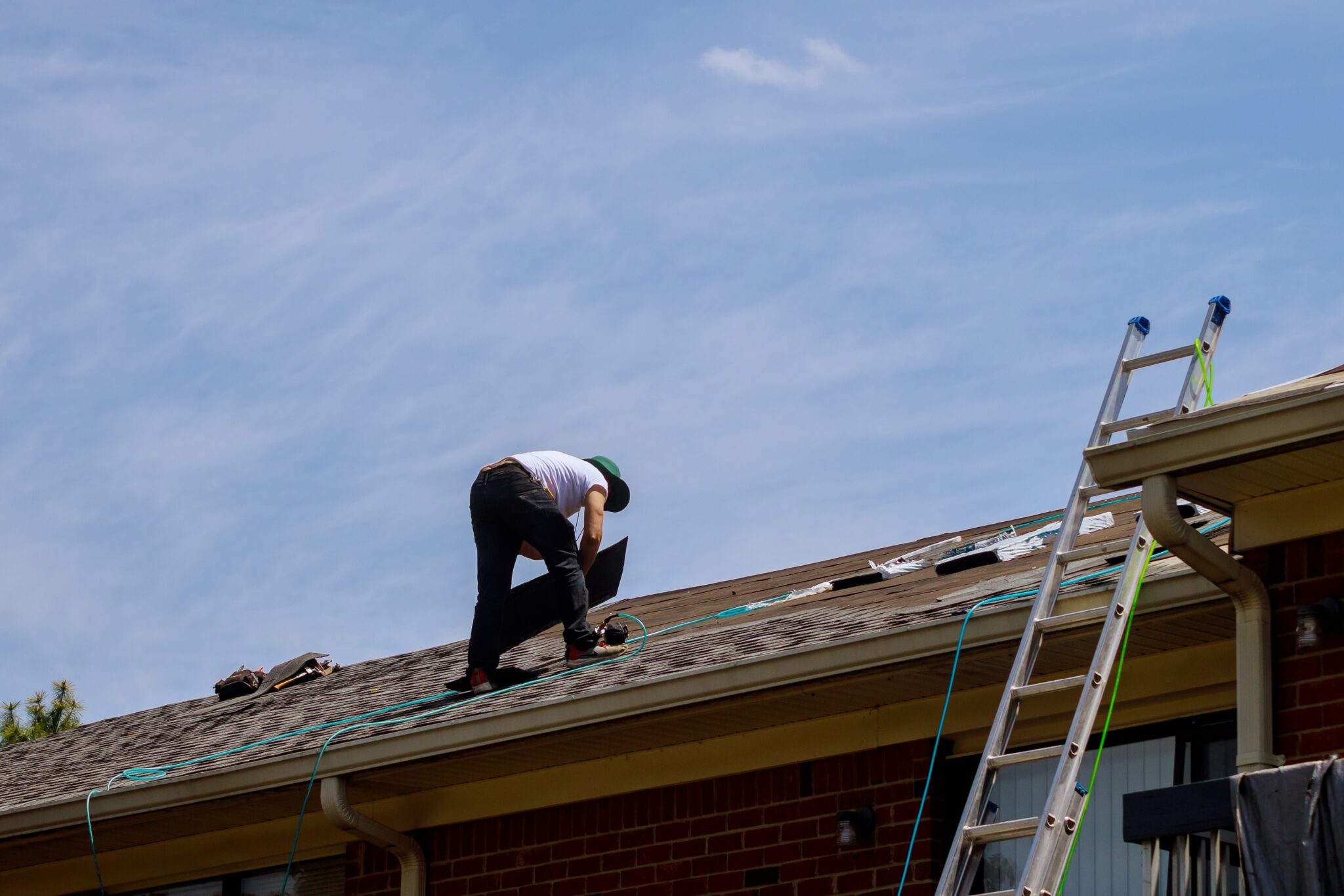 roof repair worker with replacing gray tiles shin 2025 03 27 06 15 05 utc - 12 Stones Roofing